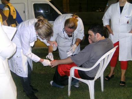 Enfermeira Odivane Vieira, ao centro, atendendo um torcedor, ao lado de uma integrante sua equipe médica. (Foto : arquivo pessoal )