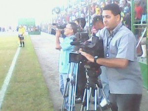 Sem cabines para os câmeras, as imagens do jogo entre Sport Club Santo Antônio e CSA foram feitas na pista do estádio de Atalaia. (Foto : Warner Oliveira ) 